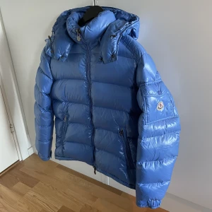 Moncler maya Sky Blue  - Säljer en Moncler maya i en sällsynt färg! Den är i bra skick! Storlek 3 vilket motsvarar M! Har en flaw! Hör gärna av dig om du har frågor!