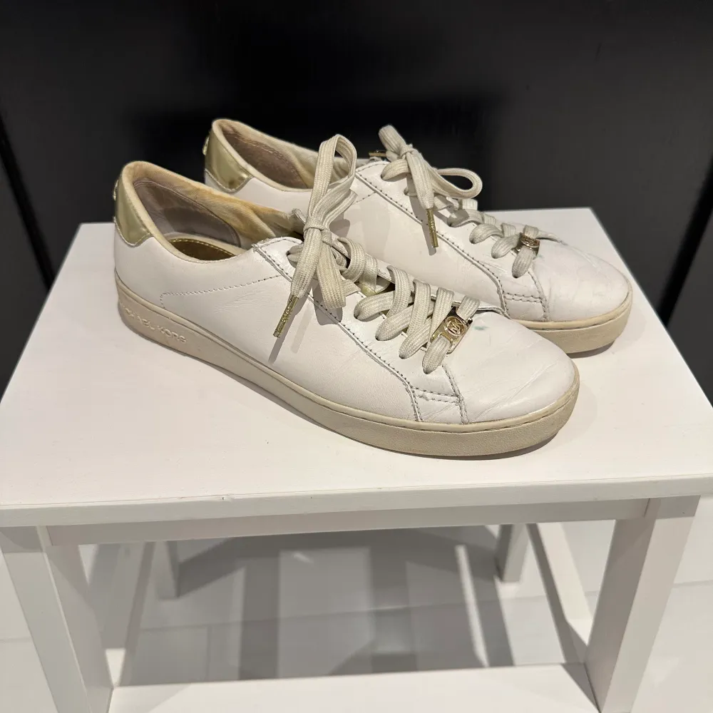 Vita MK skor med guldiga detaljer i använt skick!💛. Skor.