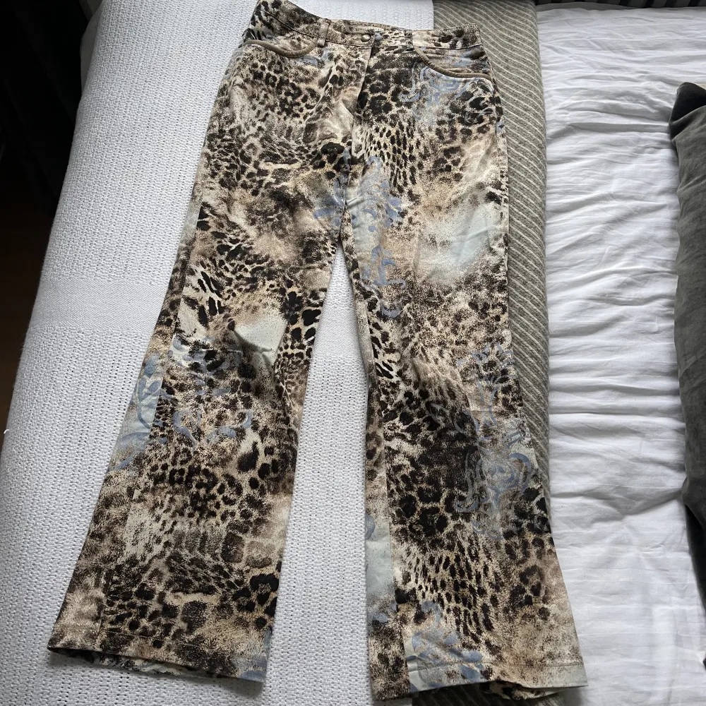 Vintage leopardbyxor i beiget svart och blått mönster. Innerbenslängd: 67 cm midjemått: 70 cm. Materialet är jeans liknande, men lite elastiskt. Inköpta second hand så vet ej märke eller exakt storlek.. Jeans & Byxor.