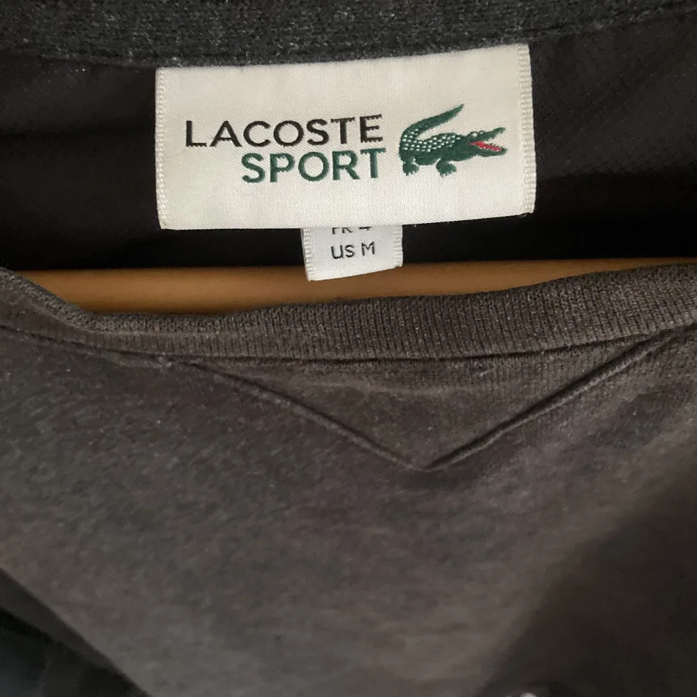 Fin Lacoste tröja i strlk M men passar även S fint skick färg mörkgrå. Hoodies.