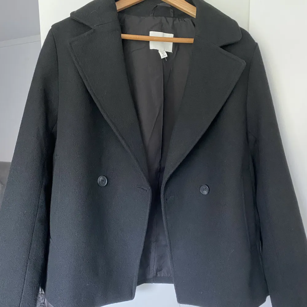 Säljer denna jättesnygga svarta kappa från HM då jag råkade köpa två likadana. Nästan helt oanvänd, den är som ny. Ordinarie pris 500kr. Pris kan sänkas 😊💕💕. Jackor.