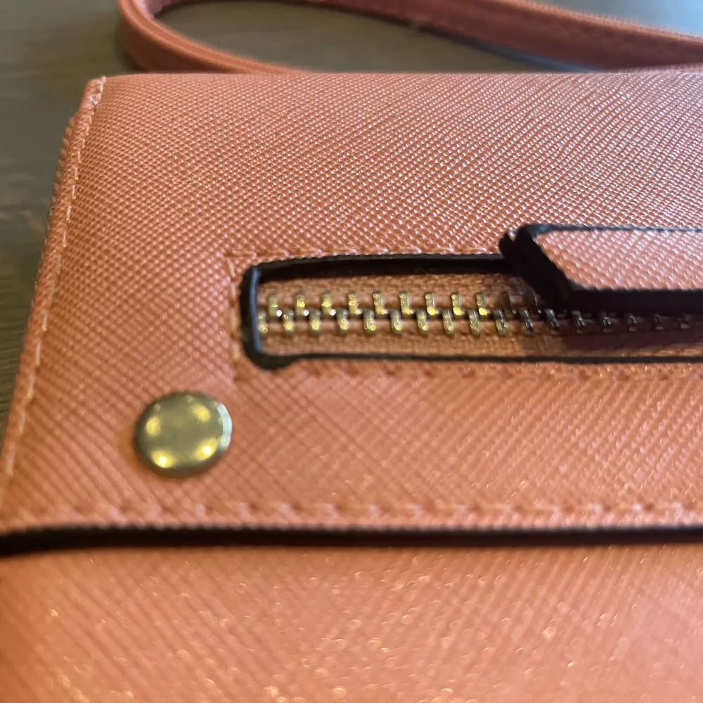 En liten väska/plånbok som man får plats med kort, pengar och andra småsaker. . Väskor.