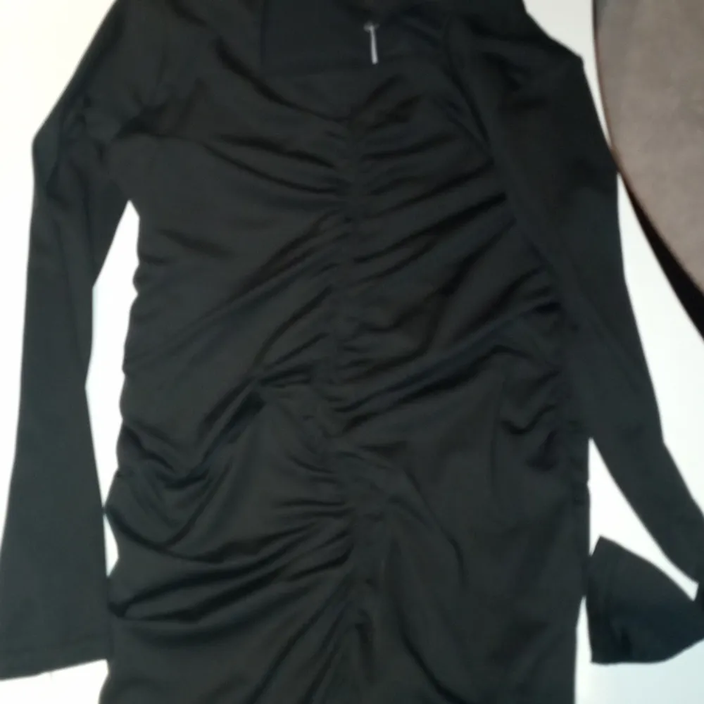En fin svart klänning med ränder på magen som är lite otydlig . Klänningar.