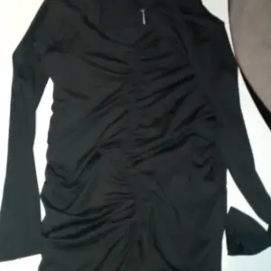 En fin svart klänning med ränder på magen som är lite otydlig 