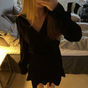 Svart klänning  - Säljer min klänning med smock och volanger ifrån Bikbok❣️ Nypris är 499 och den är i mycket bra skick!