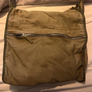 Axelremsväska  - Jätte cool grön axelremsväska💕 Köpte den på plick för ett år sen. Den har en liten skada uppe på, men inget som stör.  Kan skicka bild vid intresse 💕💕  Väskan är ganska stor och funkar jättebra som skolväska💕 