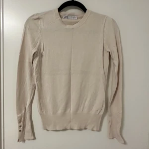 Tröja - Tröja med knappar vid ärmsluten