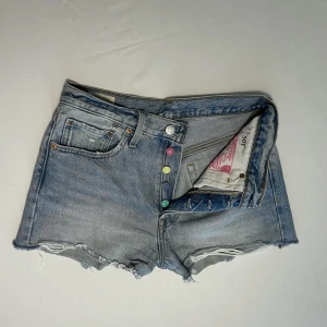 Levisshorts - Jättesnygga jeansshorts från Levis!!  Snygga färgdetaljer.  Knapparna syns inte vid användning.  Jättefint skick!! 
