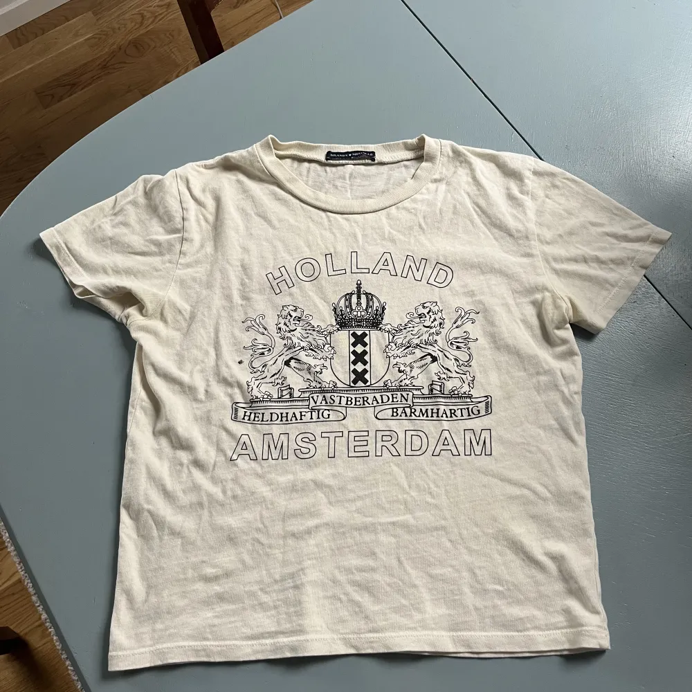 En beige T-shirt från Brandy Melville med tryck. Perfekt T-shirt för att uppdatera garderoben inför hösten! 😊Köpt för 280 kr och oanvänd.. T-shirts.