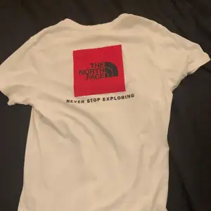 Snygg, vit The North Face t-shirt! Bra skick dock en liten fläck (se bild 2) kan säkert gå bort i tvätten men inte testat. Ordinariepris 399 kronor.