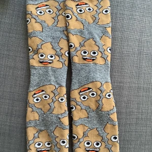 Två par strumpor bajskorvar  och smileys  - Två par strumpor storlek 18 cm i fot. Runt storlek 35-36 tror jag. Med bajskorvar och smileys, 