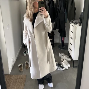 Beige lång kappa - Säljer min fina beiga kappa ifrån H&M i storlek 34. Nypris på hemsidan: 549kr. Mitt pris: 349kr🥰Hör av er för fler bilder!