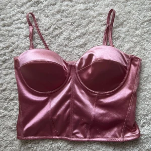 Korsettopp - Söt rosa korsettopp med dragkedja där bak. Perfekt till fest eller annat! Helt nyskick! Storlek L, men passar mindre också