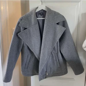 Grå kappa  - En otroligt snygg grå kappa, men dragkedja vid sidan. Super snygg och kommer ifrån bubbleroom. 