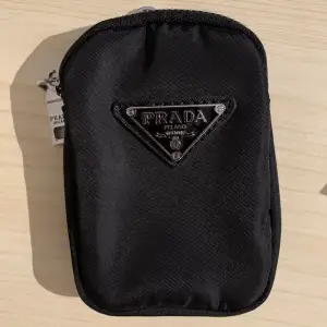 En Liten Prada ficka som går att hänga på original väskan eller som en plånbok! Väldigt bra skick. (Ej äkta)!!