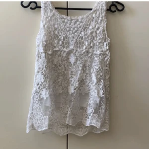 Sött vitt spets linne med mesh  - Säljer detta superfina/söta vita spetsiga linnet med fina detaljer t och med mesh längst ner, från H&M (L.o.g.g) Strlk 146/152. Köpt 2nd hand men aldrig använd av mig. I bra skick! 🤍