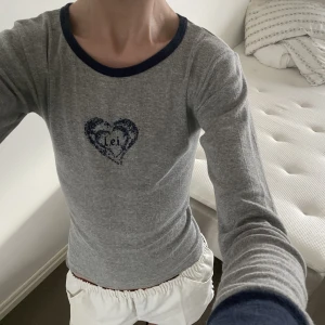 Långärmad t shirt - Grå långärmad t shirt med blå krage, muddar och jättegulligt tryck. Märket L.e.i vilket betyder hon på italienska 😀. Motsvarar ungefär s. Fint skick. 