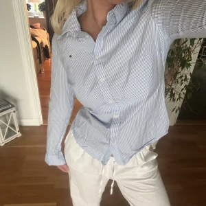 Randig Tommy Hilfiger skjorta - Randig skjorta från Tommy Hilfiger i ljusblå och vit. Storlek XS som ger en figursydd passform. Använd fåtal gånger, i mycket gott skick.🩵