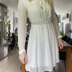 Studentklänning - Benvit klänning med långa ärmar och knytdetalj fram. Köpt på Åhléns 