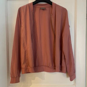 Jacka - Tunn rosa bomberjacka som man kan ha som ”kofta”, i mycket gott skick 