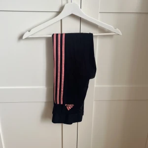 Träningsbyxor  - Träningstights från adidas med rosa strips. 