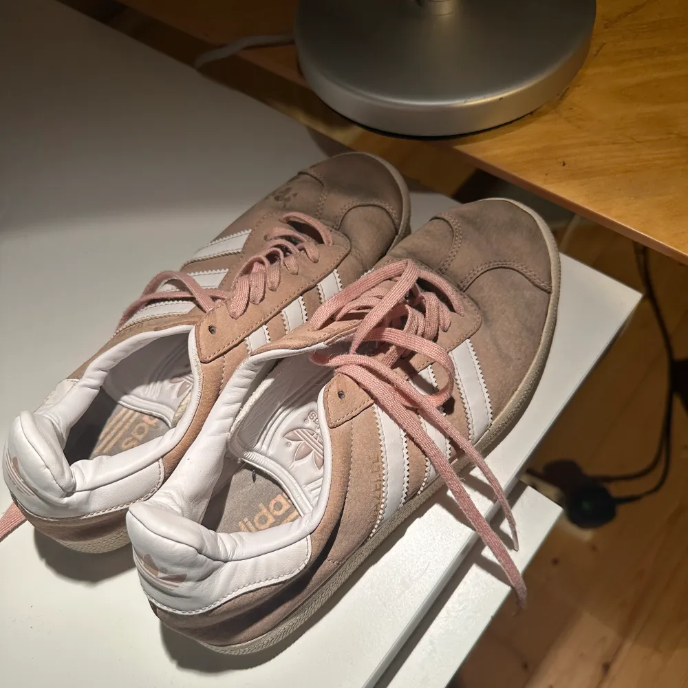 adidas sneakers i gammelrosa, finns en oljefläck vid tån på ena skon. . Skor.