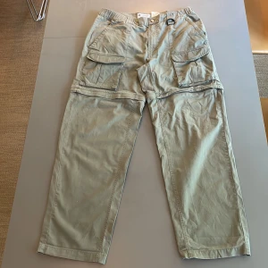 Columbia cargopants  - Säljer vintage cargopants p.g.a för små. De har hål på fållarna och lite fläckar på baksidan av benen men annars är de i bra skick. Avtagbara ben. 