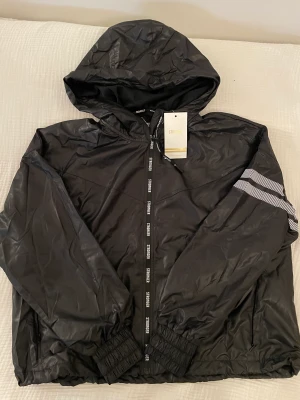 Oanvänd träningskofta - Aldrig använt med prislapp kvar. Funkar som vindjacka! 