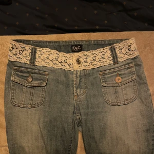 Lågmidjade Dolce & Gabbana jeans - Jättecoola lågmidjade dolce and Gabbana jeans med spetsdetaljer, raka i modellen 😍😍😍storleken står på lappen 27/41 skulle säga att de passa S. Kan fixa exakta mått och fler bilder om någon är intresserad!