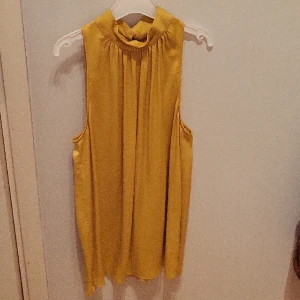 Topp/blus  - Fint skick, sparsamt använd. Snygg knäppning i nacken. Faller fint.