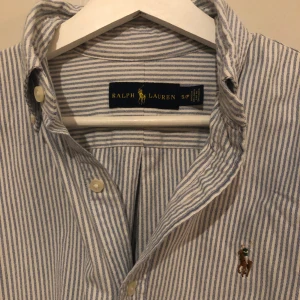 Ralph Lauren Skjorta  - Ljusblå-och vitrandig skjorta från Ralph Lauren i bra skick utan några defekter. Passformen är classic fit och sitter som en vanlig S. Skriv gärna om du har några frågor!!