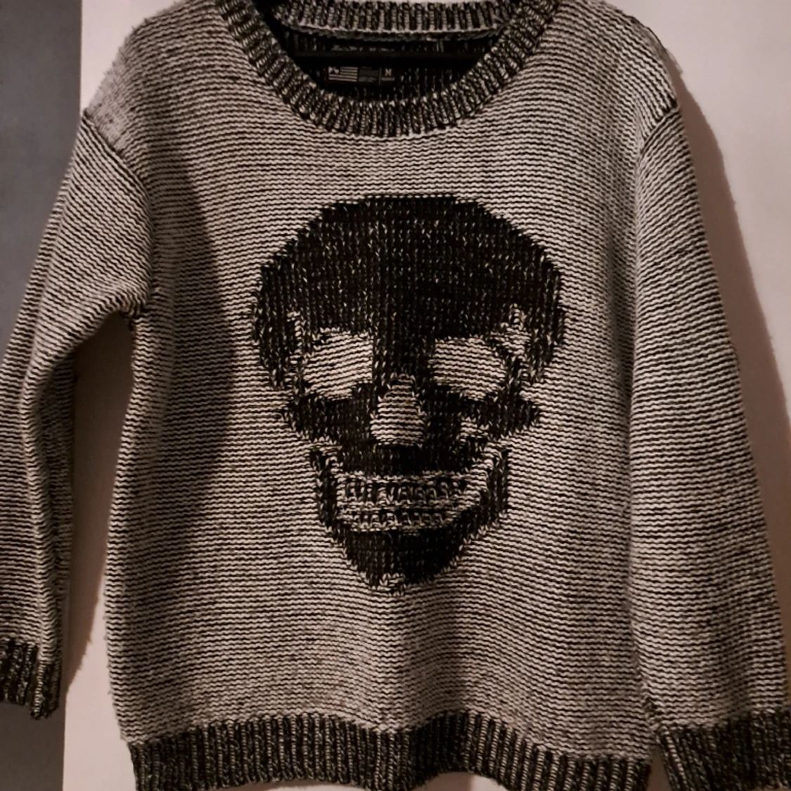 Stickad tröja med en dödskalle på