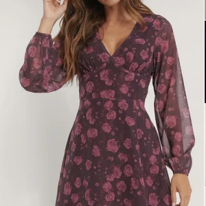 Blommig snygg klänning - Helt oanvänd pga för liten. Så himla snygg! Kramar midjan och jättefin urringning. 