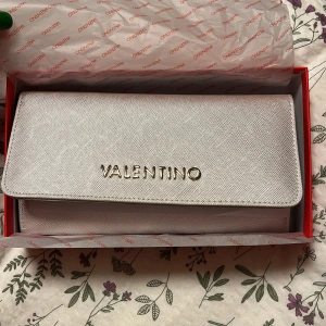 Valentino plånbok  - Super söt valentino plånbok i silvrig/guldig färg nyskick. Säljer eftersom jag har många liknande. Ny pris 599kr. Shrub gärna om ni har frågor eller funderingar 🫶🏼