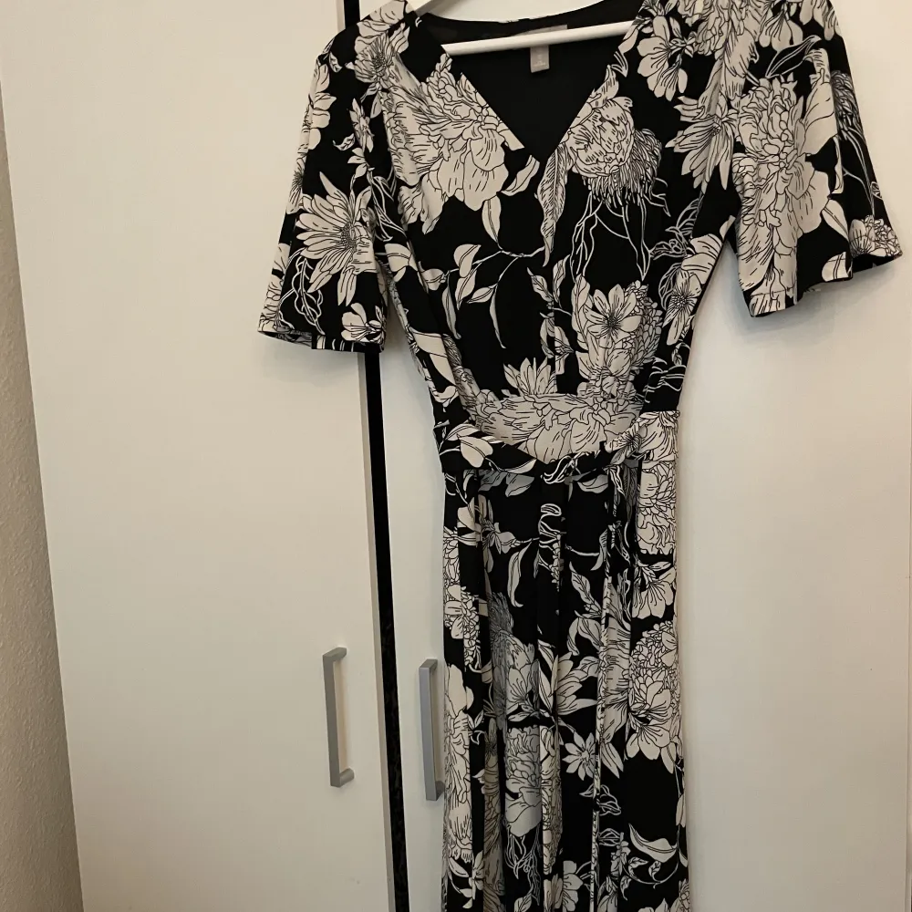 En fin klänning från H&M med knytning runt midjan. Använd ett fåtal gånger, inga defekter. Perfekt nu till sommaren!. Klänningar.