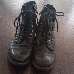 Svarta skor - Snygga skor i bra skick köpta för 2 år sedan från tamaris. Har två dragkedjor på framsifan samt skosnören. Dom yttre dragkedjorna fungerar inte då dom endast är prydnad. Ena skosnöret har en liten defekt (se bild 3).  Kontakta gärna. 