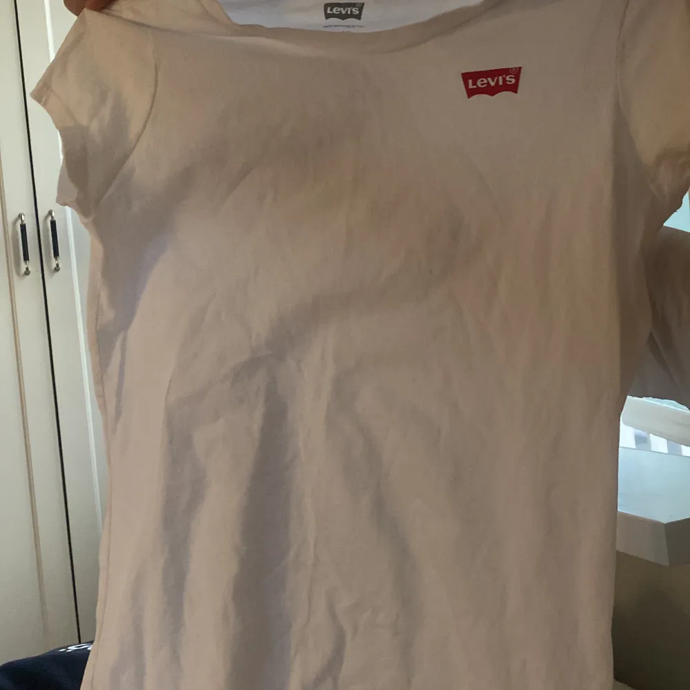 en vit T shirt från Levis med ett rör Levis  märke helt oanvänd . T-shirts.