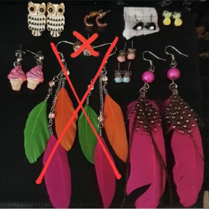 Blandade örhängen - Blandade örhängen, 15kr/par. Vänster till höger, uppifrån o ner: Ugglor, glassar(sålda!), "halva" ringar, kristaller(sålda!), orange rosa grön fjäder, svarta hjärtan med kristall, rosa pluppar, blå pluppar, ananaser, rosa fjädrar. Rengörs självklart innan. Pris kan diskuteras. Skickas mot fraktkostnad.