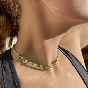 Halsband  - Ett handgjort mackrame halsband med vit bomullstråd och gröna glaspärlor i blomm motiv!💚 halsbandets storlek kan justeras och har två snören bak till de. Den största storleken på halsbandet är ca 70 cm och minsta ca 42 cm!