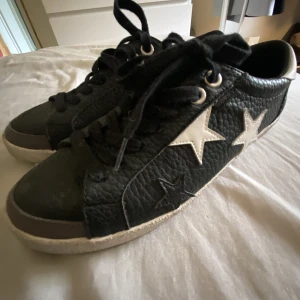 Skor - Svarta skor med stjärnor på , väldigt fräna och bra till sommaren . Sköna o gå i samt snygga .likande lite goldengose skor .