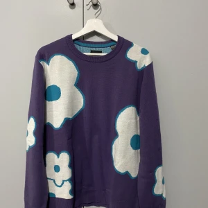 Stickad tröja - Stickad långärmad med mönstrade blommor. Färgen är lite mörkare lila. Säljer då det ej är min stil.