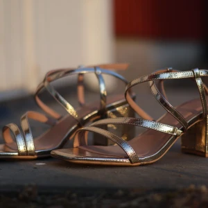 New Look klackskor - Helt nya Wide Fit klackar från New Look. Köpta i Brighton, men är för små, och säljs därför oanvända. Storlek 39. Reglerbart spänne framtill. Ca 5 cm klack. Guldiga. Kan båda skickas och mötas upp, finns i Vårgårda.  