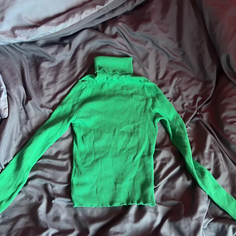 Grön tröja, välldigt töjbart material. Storlek XS men funkar på alla storlekar upp till L. Toppar.