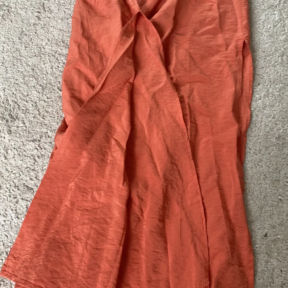 Finn lång kjol från H&M. Rostbrun/orange med fickor och slits vid sidan av benen. Fint skick.. Kjolar.