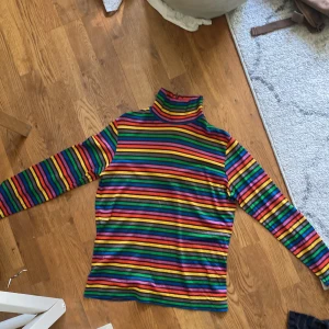 Regnbågsfärgad polotröja  - Säljer denna fina polotröja, den har ett blixtlås där bak (se bild). Säljer denna för att den inte har kommit till så stor användning. 😊