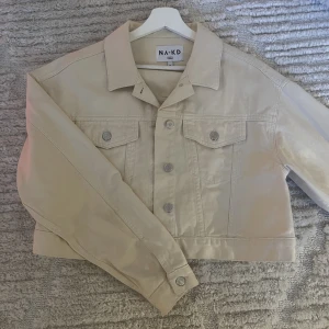 Beige jeansjacka - Säljer denna härliga jeansjacka från nakd. Lite cropad. Storlek 40. Köparen står för frakten💕