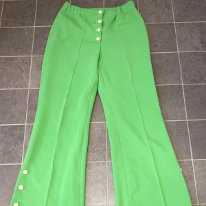 Gröna byxor - Finns matchande tröja till med knappar. Köpt i Gotland från familj som sytt klädseln själv. Aldrig använt själv. Skönt material och det är bra skick.