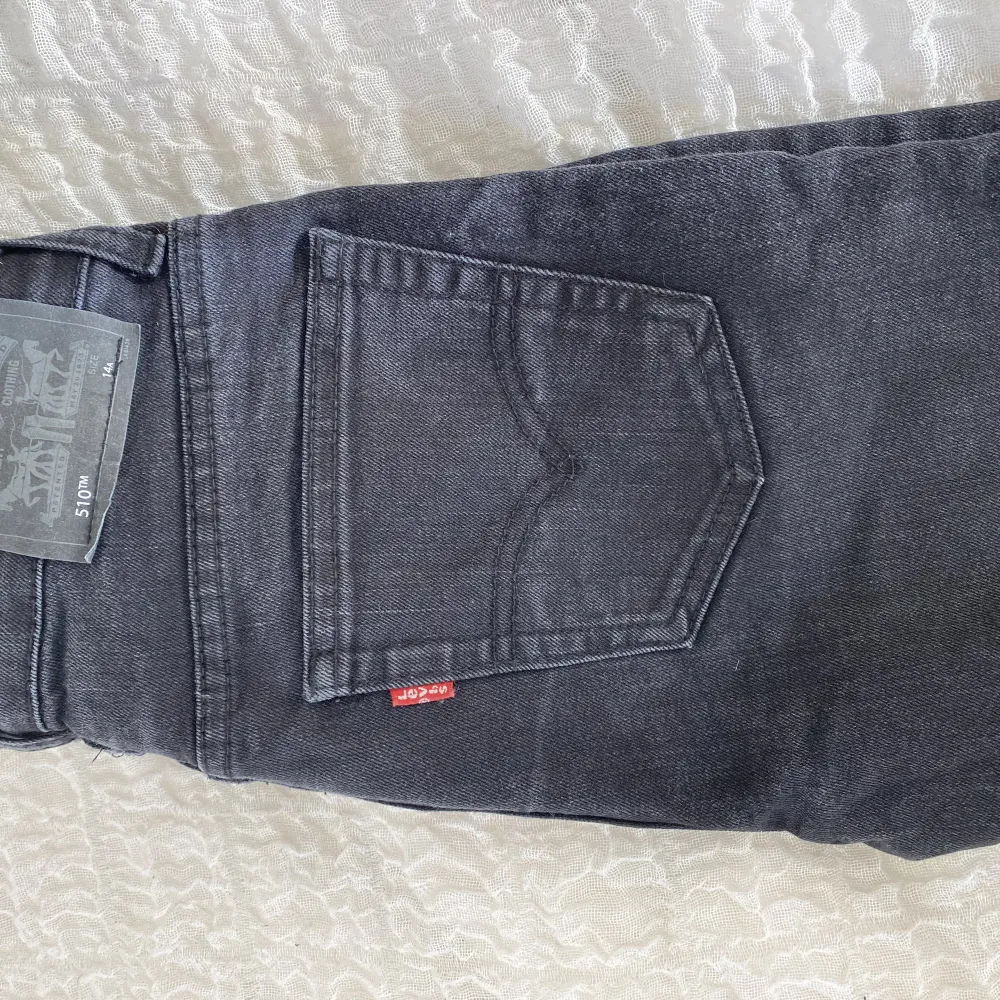 Ett par svarta/mörkgrå Levisjeans modell 510 Skinny i nyskick men utan prislapp. Size 14A, 164cm. Jeans & Byxor.