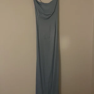 Maxi klänning från na-kd  - En ljusblå maxiklänning med snygga detaljer i ryggen Jag är 1,70 och den går precis ner till fötterna