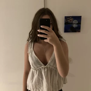 Topp - Vit, beige topp med ränder, knyts vid axlarna. Sitter tajtare vid brösten och lösare vid magen. Storlek XS eller S (aldrig använt)